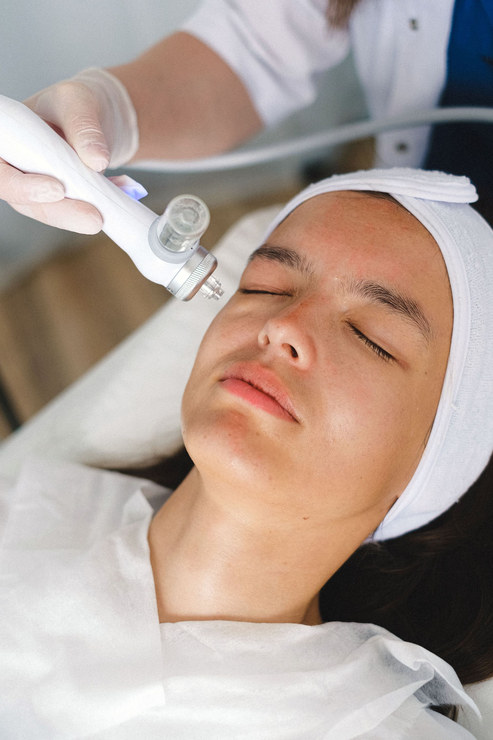 High angle of crop doctor in protective gloves using ultrasound equipment for treatment therapy in beauty salon